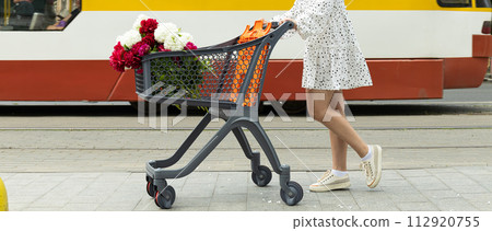 A beautiful girl with a cart with flowers on the street. A beautiful girl with a cart with flowers on the street. 112920755