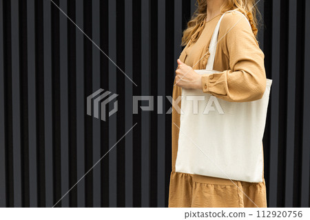 A girl in a summer outfit with a reusable shopping bag. 112920756