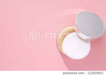 A bottle of powder, light shade, on a pink background. A bottle of powder, light shade, on a pink background. 112920851