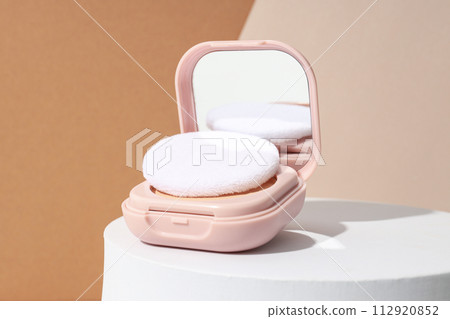 A bottle of powder, light shade, on a beige background. 112920852