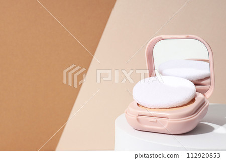 A bottle of powder, light shade, on a beige background. 112920853
