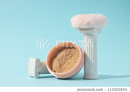 A bottle of loose powder, light shade, on a blue background. A bottle of loose powder, light shade, on a blue background. 112920859