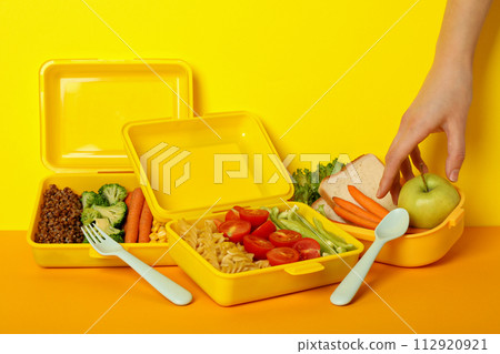 Yellow lunch box with food on a yellow background 112920921