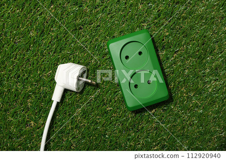 Electric socket with cable on the grass Electric socket with cable on the grass 112920940
