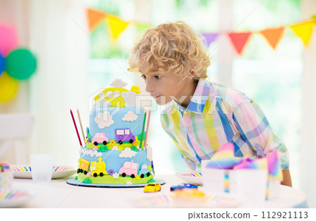 Kids birthday party. Child blowing out cake candle Kids birthday party. Child blowing out cake candle 112921113