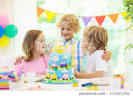Kids birthday party. Child blowing out cake candle 112921392