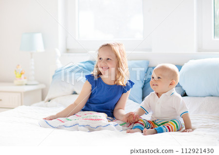 Kids playing on parents bed 112921430