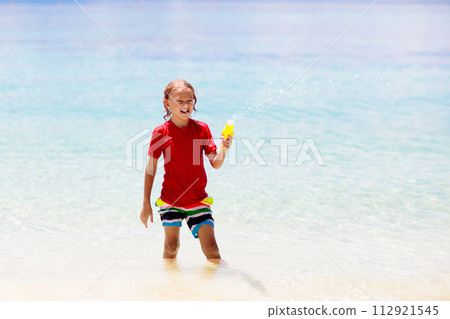 Child with toy water gun. Kids vacation beach fun. Child with toy water gun. Kids vacation beach fun. 112921545