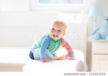 Baby boy crawling on bed 112921554