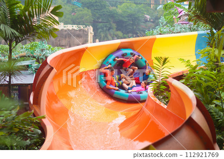 Kids on water slide. Family in aqua theme park. 112921769