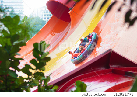 Kids on water slide. Family in aqua theme park. Kids on water slide. Family in aqua theme park. 112921775