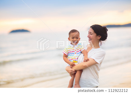 Mother and baby on tropical beach at sunset. Mother and baby on tropical beach at sunset. 112922212