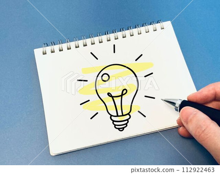 draw a miniature light bulb on paper 112922463