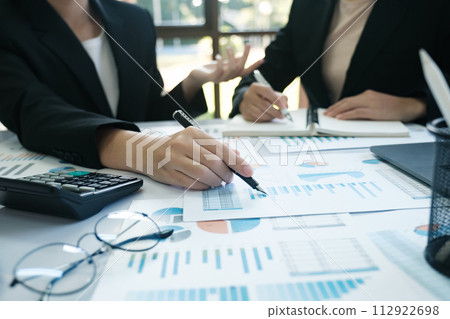 Two women in suits are working on a project together 112922698