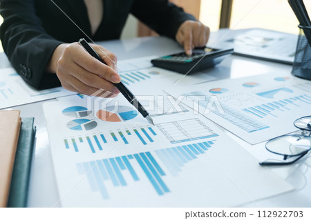 A person is writing on a piece of paper with a pen 112922703