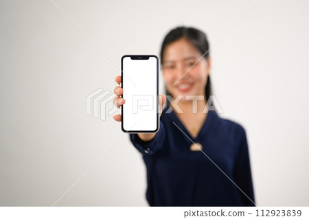 Portrait of a smiling woman showing smartphone for your webpage or advertise text Portrait of a smiling woman showing smartphone for your webpage or advertise text 112923839