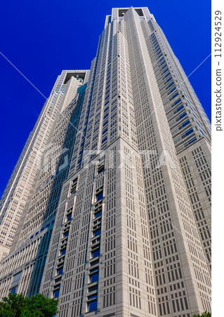 Tokyo Metropolitan Government Building towering against the clear blue sky in autumn (Shinjuku-ku, Tokyo) 112924529