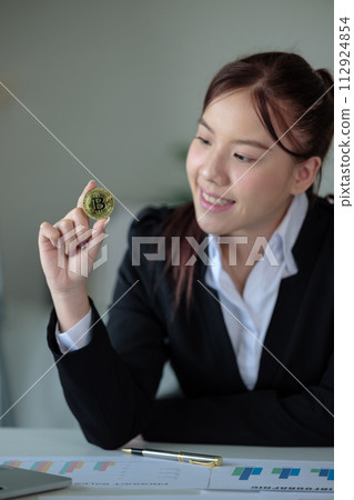 Business woman look at Bitcoin btc cryptocurrency as saving bank account currency in finance exchange trade for digital money gold technology cash. Person invest in electronic online payment market 112924854