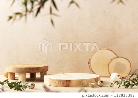 Empty round wooden podiums, quail eggs with green eucalyptus branches on a beige background Empty round wooden podiums, quail eggs with green eucalyptus branches on a beige background 112925392