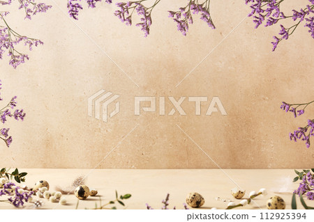 Easter background concept with quail eggs and spring flowers on a beige background. Front view Easter background concept with quail eggs and spring flowers on a beige background. Front view 112925394