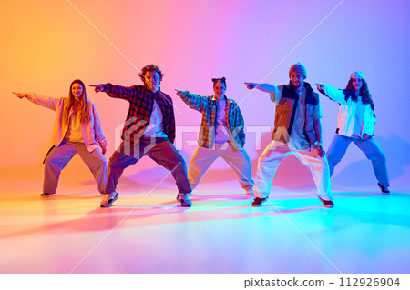 Artistic five dancers, young man and woman in motion, dancing against gradient studio background in neon light 112926904