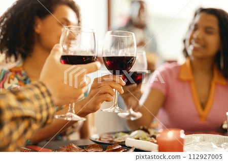 Close up of smiling friends drinking wine and enjoying time together at holiday dinner party at home Close up of smiling friends drinking wine and enjoying time together at holiday dinner party at home 112927005