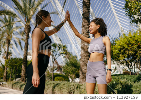 Sporty women greeting together outdoor doing gesture of shake hand after exercising 112927159