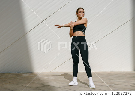 Sporty woman does warm-up exercises in morning before running training outside. Healthy fitness Sporty woman does warm-up exercises in morning before running training outside. Healthy fitness 112927272