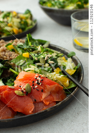 Buckwheat with fried egg and salmon fish, mix salad with fresh herbs and peppers Buckwheat with fried egg and salmon fish, mix salad with fresh herbs and peppers 112928146