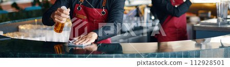 Header with bartender wiping and disinfecting bar counter Header with bartender wiping and disinfecting bar counter 112928501