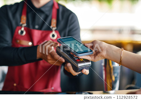 Woman using mobile payment app for order in restaurant Woman using mobile payment app for order in restaurant 112928572