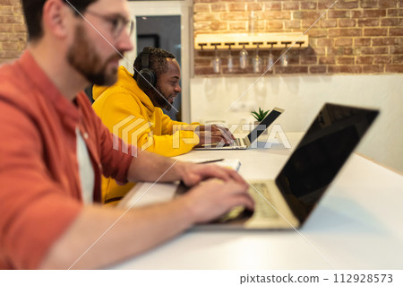 Two colleagues working together and looking serious Two colleagues working together and looking serious 112928573