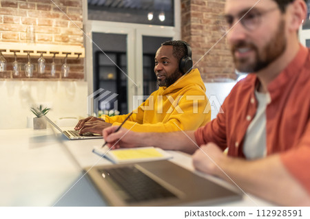 Two men looking involved while working in a home office 112928591