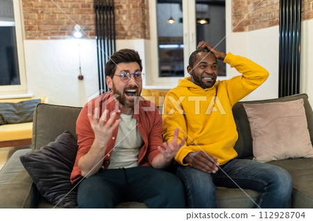 Two men watching football and looking excited 112928704