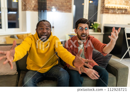 Two men watching football and looking excited 112928721