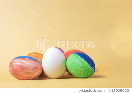 Colorful painted easter eggs on a yellow background with copy space. 112929000