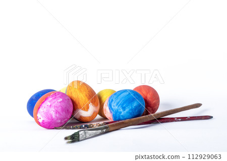 Colorful painted Easter eggs and paint brush on white background Colorful painted Easter eggs and paint brush on white background 112929063