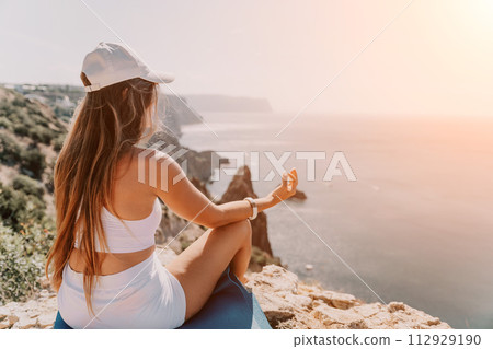 Woman sea yoga. Happy woman meditating in yoga pose on the beach, ocean and rock mountains. Motivation and inspirational fit and exercising. Healthy lifestyle outdoors in nature, fitness concept. 112929190