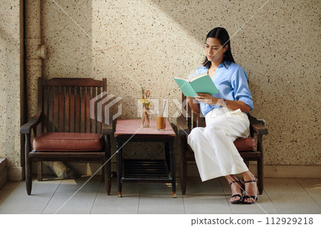 Woman spending time in cafe, drinking coffee and reading book Woman spending time in cafe, drinking coffee and reading book 112929218