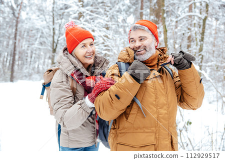 Mature couple in a winter forest feeling happy 112929517
