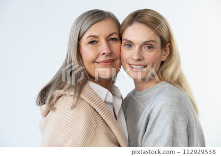 Mother and daughter standing together and looking relaxed 112929538