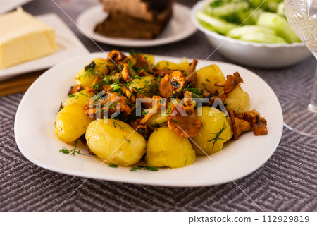 Rustic dish. fried potatoes with chanterelle mushrooms with herbs Rustic dish. fried potatoes with chanterelle mushrooms with herbs 112929819