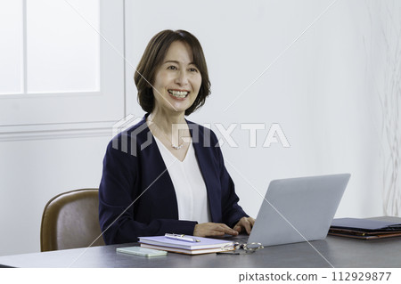操作筆記型電腦的中年職業女性 操作筆記型電腦的中年職業女性 112929877