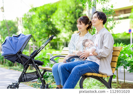 一對年輕夫婦抱著一個嬰兒 112931020