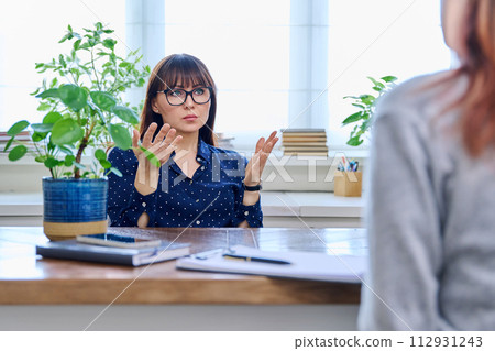 Mature sad woman in therapy session with mental professional 112931243