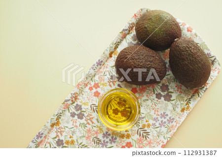 oil and slice of avocado on wooden table  112931387