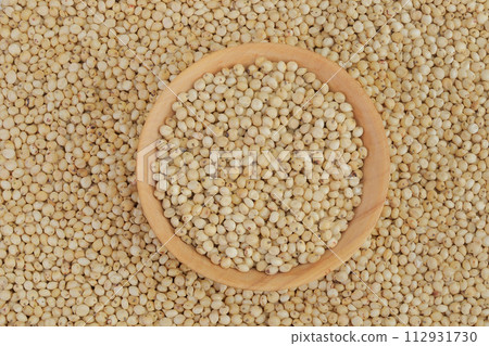 background of sorghum seeds with wooden bowl. Top view. Flat lay. background of sorghum seeds with wooden bowl. Top view. Flat lay. 112931730