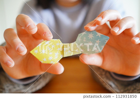 An elementary school child folded a ribbon using origami. 4th grade elementary school student, 10 years old. An elementary school child folded a ribbon using origami. 4th grade elementary school student, 10 years old. 112931850