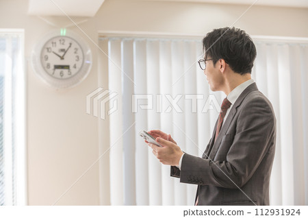 一位關心時間的西裝男商人 112931924