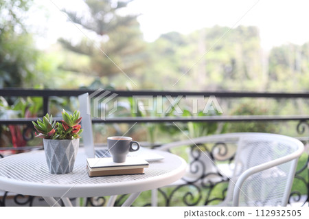 Laptop side view and coffee cup on white table outdoor Laptop side view and coffee cup on white table outdoor 112932505